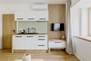 - une cuisine avec des placards blancs et un évier dans l'établissement BALANCE apartments, à Znojmo