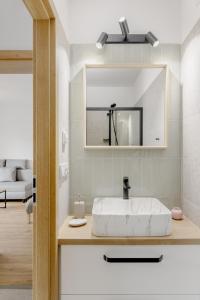 La salle de bains est pourvue d'un lavabo blanc et d'un miroir. dans l'établissement BALANCE apartments, à Znojmo