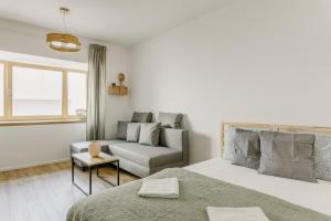 - une chambre blanche avec un lit et un canapé dans l'établissement BALANCE apartments, à Znojmo