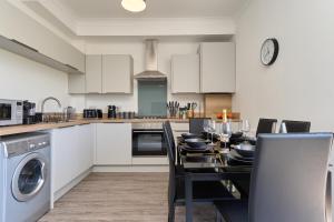 a kitchen and dining room with a table and chairs at Meadow View - A Beautiful 3 Bed Apt With Stunning Countryside Views & Parking - Close To Ventnor, Shanklin & Sandown - 5 mins To Beach - Ideal For Friends, Families, & Business Stays - Dog Friendly - 17 in Ventnor
