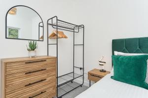 Dormitorio con cama con espejo y tocador en Stunning 3 Bed Apt With Countryside Views & Parking - Ideal For Families, Groups & Business Stays - Close To Ventnor, Shanklin & Sandown en Ventnor