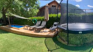 um pátio com 2 cadeiras e uma piscina em Platzerhof em Monguelfo