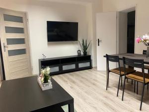 a living room with a table and a television on a wall at Ubytovanie v centre FREE PARKING in Martin