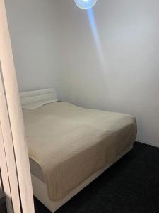 een bed in een kamer met een witte muur bij Ubytovanie v centre FREE PARKING in Martin