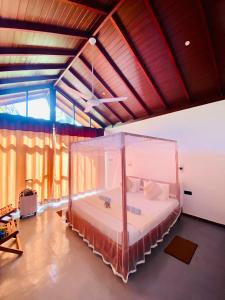 a bedroom with a large bed with a canopy at Mango Tree House in Udawalawe