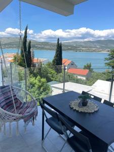 un tavolo e sedie su un balcone con vista sull'acqua di Apartmani Marko a Trogir