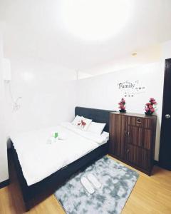 - une chambre avec un lit blanc et un tapis dans l'établissement Chael Staycation - Minimalist Modern 1-Bedroom, à Marilao