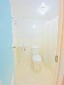 La salle de bains blanche est pourvue de toilettes et d'un lavabo. dans l'établissement Chael Staycation - Minimalist Modern 1-Bedroom, à Marilao