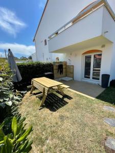 uma mesa de piquenique de madeira em frente a uma casa em Joli appartement avec jardin à 400m de la plage em Anglet