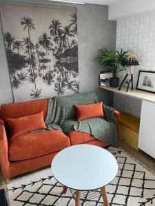 uma sala de estar com um sofá e uma mesa em Joli appartement avec jardin à 400m de la plage em Anglet