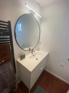 uma casa de banho com um lavatório branco e um espelho. em Joli appartement avec jardin à 400m de la plage em Anglet