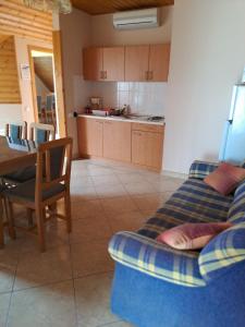 een woonkamer met een bank en een tafel en een keuken bij Alinka Apartmanház in Balatonlelle