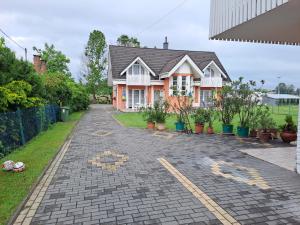a house with a brick driveway in front of it at Alinka Apartmanház in Balatonlelle