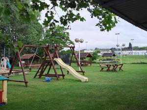 een speeltuin met een glijbaan in een park bij Alinka Apartmanház in Balatonlelle