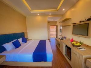 a bedroom with a large bed and a flat screen tv at Majestic Lake Front Hotel & Suites in Pokhara