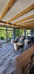 - une salle à manger avec des tables, des chaises et des fenêtres dans l'établissement Mestia Roots, à Mestia