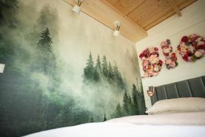a bedroom with a large painting of trees on the wall at Bloom& Breakfast in Kleve