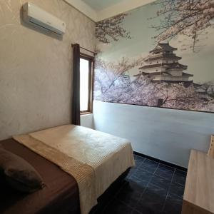 a room with a bed and a painting on the wall at Unique Homestay 443 in Yogyakarta