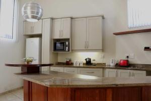 a kitchen with white cabinets and a granite counter top at The Gilded Dragonfly Guesthouse in Margate