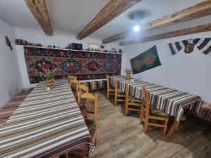 una fila de mesas y sillas en una habitación en Pensiunea Agroturistica Casa Coliniţa, en Vatra Moldoviţei