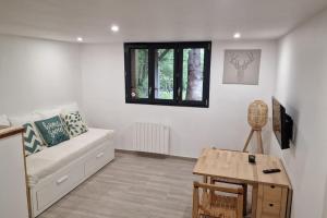 sala de estar con sofá y mesa en Ariège, agréable appartement en bord de rivière, en Vicdessos