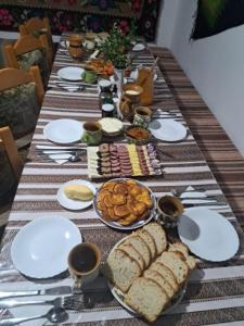 a long table with plates and food on it at Pensiunea Agroturistica Casa Coliniţa in Vatra Moldoviţei
