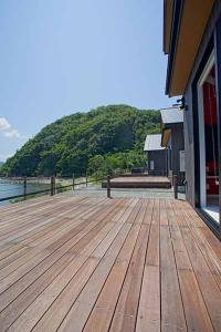 a large wooden deck with a view of the water at Rainbow Village（レインボーヴィレッジ） in Mihama