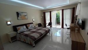 een slaapkamer met een bed, een bureau en een raam bij Villa Shangri-La in Dumaguete