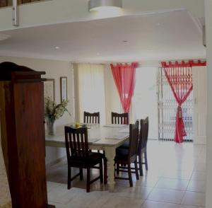 a dining room with a table and chairs at Phoenix Lodge - Ramsgate KwaZulu Natal in Margate +17 photos