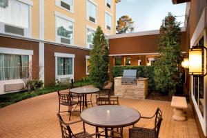 un patio con tavoli e sedie di fronte a un edificio di Fairfield Inn & Suites Houston Intercontinental Airport a Houston