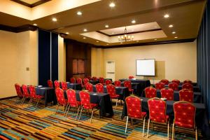 una sala conferenze con tavoli, sedie rosse e schermo di Fairfield Inn & Suites Houston Intercontinental Airport a Houston Altre 19 foto