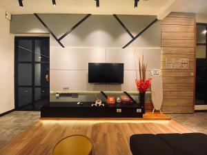 a living room with a flat screen tv on a wall at SIX Boutique Residence @ Ipoh Garden Landed House 8pax in Ipoh +20 photos