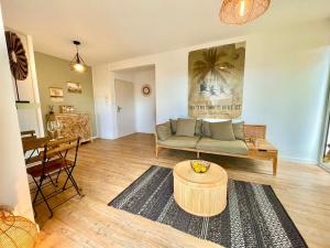 a living room with a couch and a table at Le Céladon Saint Gilles les Bains in Saint-Gilles les Bains