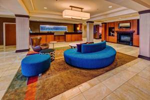 a lobby with two blue chairs and a fireplace at Fairfield Inn & Suites Memphis Olive Branch in Olive Branch