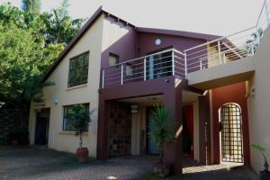 a house with a purple and white at Phoenix Lodge - Ramsgate KwaZulu Natal in Margate