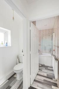 a white bathroom with a toilet and a tub at Entire Charming 5-Bed House in Darwen Blackburn BB1 Free Parking Roadside in Rishton