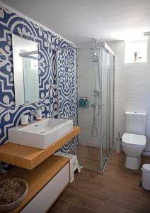 a bathroom with a sink and a shower and a toilet at Merastri Villa in Zaros