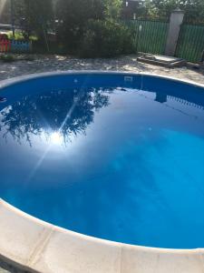 a swimming pool with blue water in a yard at Sunshine villa Dzhigurovo in Sandanski