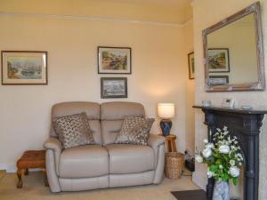 a living room with a couch and a mirror at Waterside Cottage in Saltash
