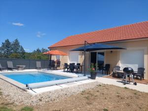 a backyard with a swimming pool and a house at Vacances Vallée de la Dordogne in Souillac