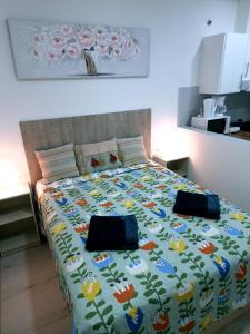 Una cama con una manta con pájaros y flores. en Apartamentos ZANCA CITY CENTER, en Málaga