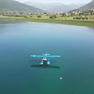 een vliegtuig vliegt over een lichaam van water bij Apartmani Ambiente in Plav