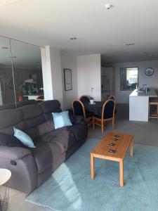 a living room with a brown couch and a table at Quayside Luxury Apartments in Whakatane