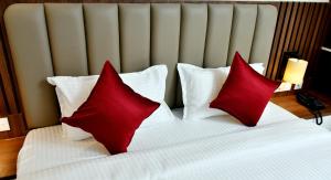 Nāmakkal的住宿－Kailash Residency，一张带两个红色枕头的床