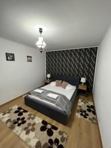 1 dormitorio con 1 cama grande y cabecero negro en Guesthouse Viktoria Pensiune, en Praid