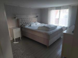 1 dormitorio con 1 cama grande y ventana en Vadstena semesterlägenhet en Vadstena
