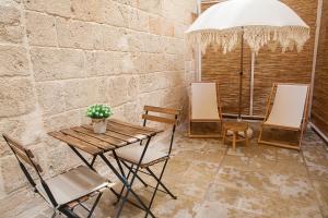 Un patio con una mesa y sillas y una sombrilla. en Terra d'Acqua, en Monopoli