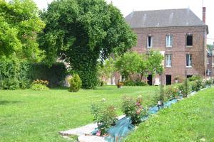 a garden with flowers in front of a house at Domaine de l'Hyères in Grandcourt