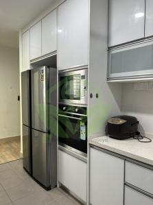 a kitchen with a refrigerator and a microwave at 3R@7pax++ Spacious Space Putrajaya. in Putrajaya