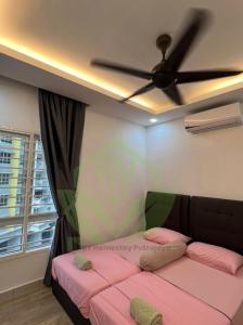 a bedroom with a ceiling fan and a pink bed at 3R@7pax++ Spacious Space Putrajaya. in Putrajaya